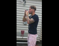 guy with pink shorts opens beer with his head 