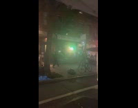 Two guys sword fight inflatable tube sidewalk