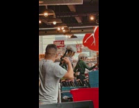 Couple in Helmet-Sized Face Mask at Supermarket