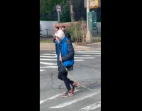 Person dragging rope while crossing street 