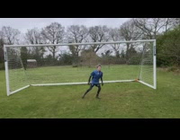 Goalie blue shirt blocks soccer ball and hits face on goal post pole