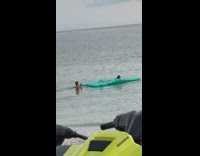 Guy in ocean girl blue inflatable float 