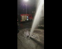 Water shoots out from asphalt ground 