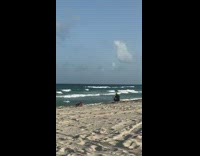 Woman yellow bikini crawl towards camera beach