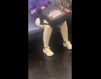 Woman rides train with black LED backpack