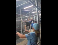 Man swings across the bar of scaffolding