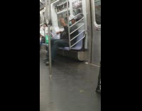 Guy sits beats drumsticks against lap subway