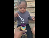 Baby trying to blow bubble wand 