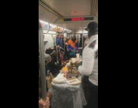 Group of friends set up table to eat Thanksgiving dinner on subway train