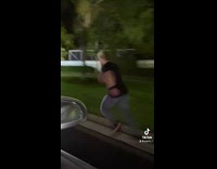 Guy running alongside car trips and falls