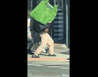 Guy carries grass chair cross the street