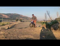 Dirt biker goes over hill with beer 