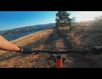Girl rides orange bicycle around mountain 