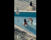 Woman red bikini poses on pool sunbed