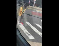 Guy breakdances alone crosswalk yellow jacket 