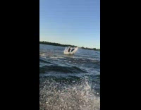 Guy riding jet ski jumps lifts feet 
