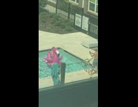 Woman in pink bikini rides inflatable flamingo