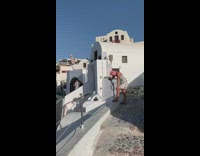 Woman white top stand rooftop house Santorini
