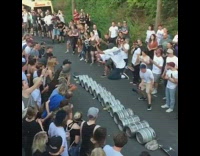 Guy skateboard jumps over beer kegs