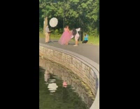 Girl pink dress park pond reflector stand