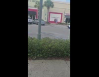 Woman black dress in front of Victoria's Secret wall for photoshoot