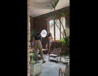 Woman in floral top leans by the window