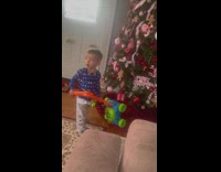 Boy hits Christmas tree with toy lawn mower
