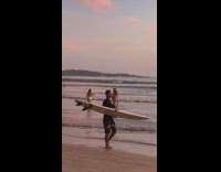 Two girls bikini santa hat beach sunset