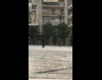 Man Walks Across Townsquare as it Rains