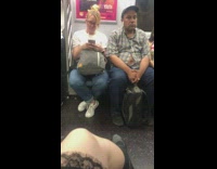 Man unbuttons green blue plaid shirt shirt and bellybutton shows  on subway