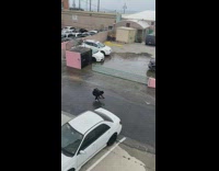 Woman poses for photos in front of broken water pipe 
