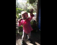 Girl plays harmonica and dances at backyard