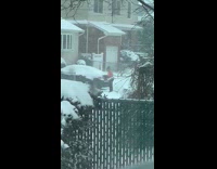 Girl wearing pink sports bra shovels snow 