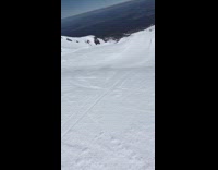 Skier backflips off ramp down mountain, lands and skis pop off legs 