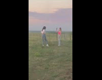 White shirt girl points toe grass sunset