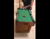 Guy shoot two balls small pool table
