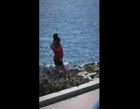 Guy red top flex muscles sea sunny