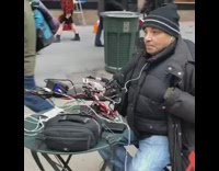 Guy records himself with 6 phones and talks into microphone in middle of street