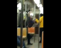 Guy blue sweater lifts himself in the air whole holding onto poles on subway train