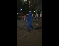 person dances in fake cookie monster outfit nighttime 