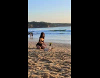 Collab IITW - Woman in bikini poses with a book in front of the phone at the beach black dog start