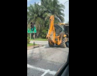 Man Drives Backhoe Loader on Main Road