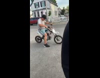 Blue shorts guy wheelie white dirt bike 