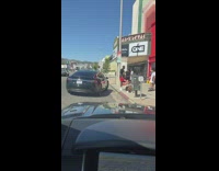 Woman white dress pose beside red building