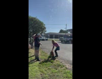 Two men promote soil bag outside window