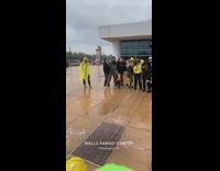 Group of kids singing with yellow and neon green ski mask in front of school
