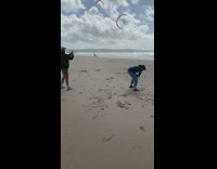Woman blue jacket run circles beach sands