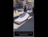 Man walk on street drag bed mattress