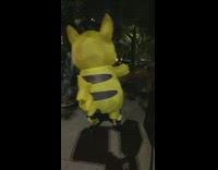Person in pikachu mascot walk street night