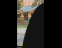 Woman in green suit poses on the sidewalk